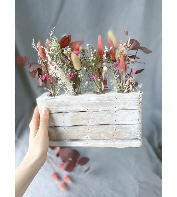 houten rekje met droogbloemen in witte en roze kleuren